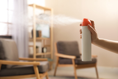 Photo of Woman spraying air freshener at home, closeup