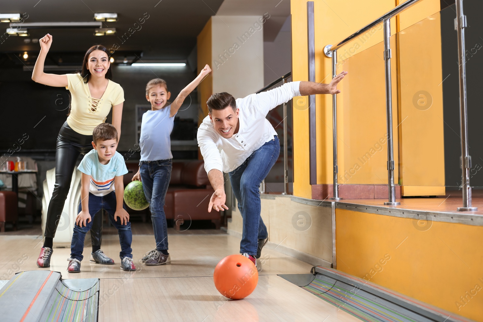 Photo of Happy family spending time together in bowling club