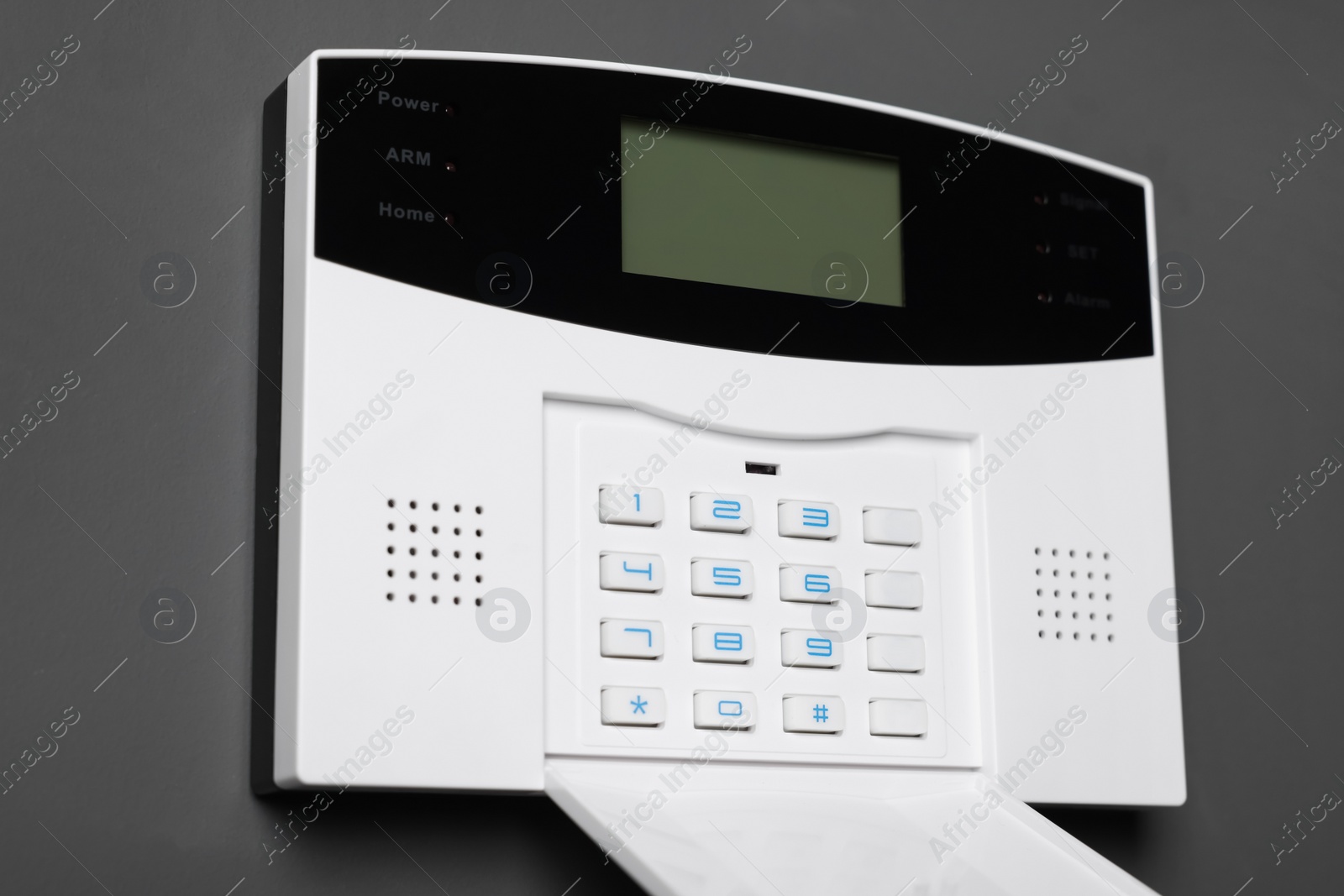 Photo of Home security alarm system on gray wall, closeup