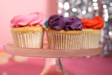 Photo of Delicious cupcakes with bright cream on pink table, closeup