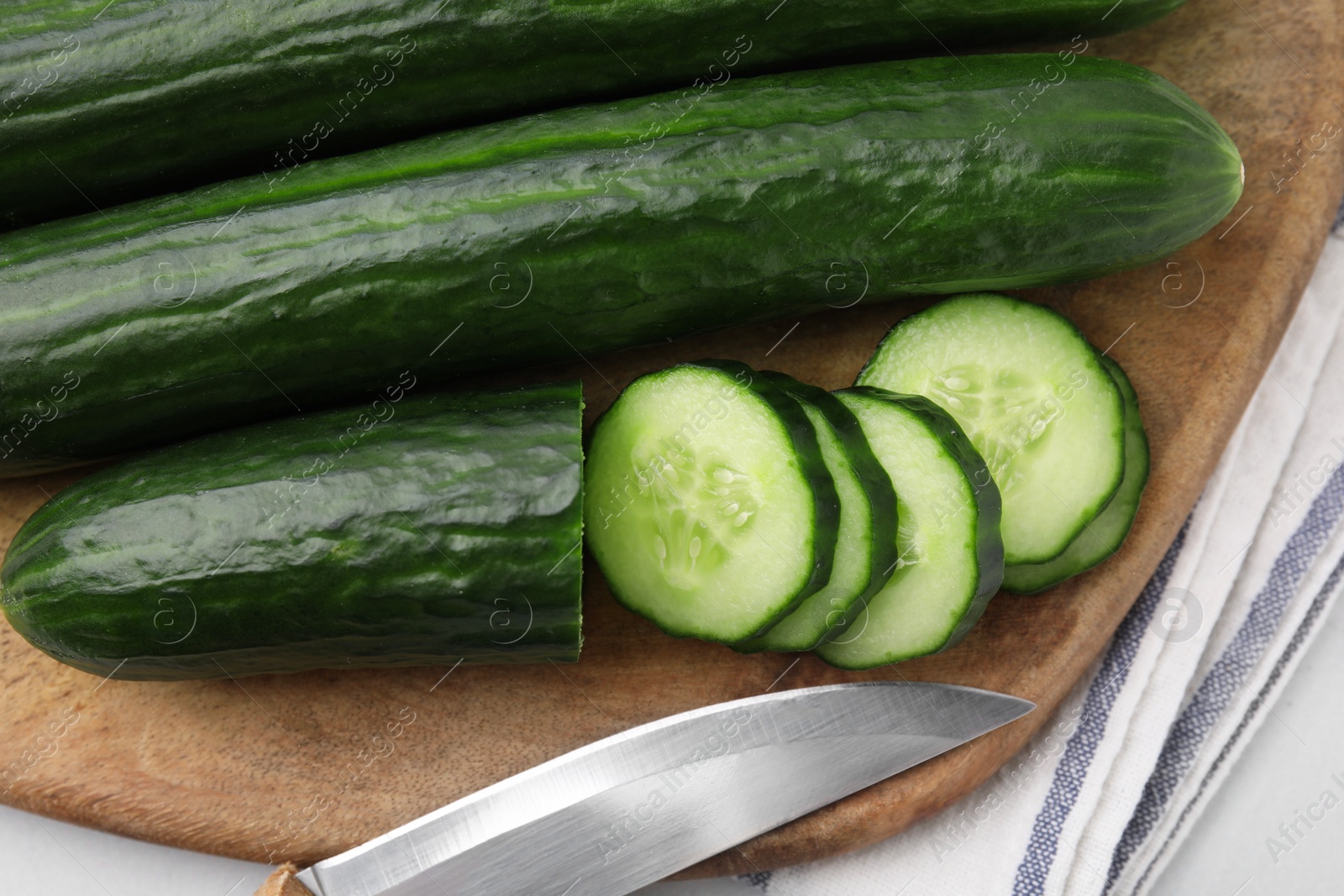 Photo of Fresh cucumbers and knife on table, top view