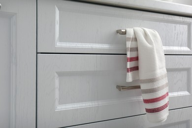 Soft kitchen towel hanging on drawer handle indoors