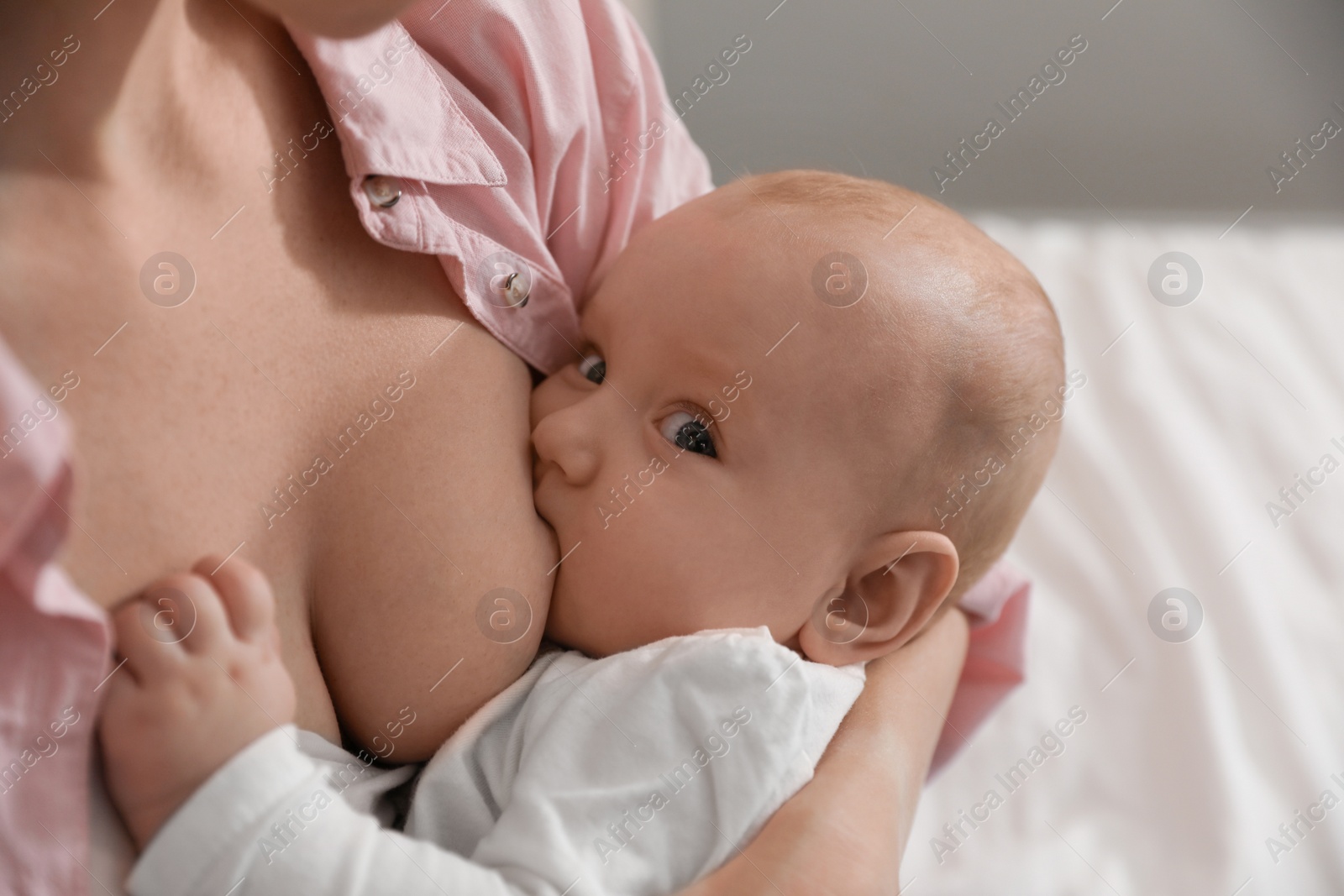 Photo of Young woman breast feeding her little baby, closeup