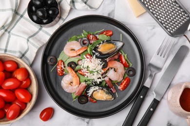 Photo of Plate of delicious salad with seafood on white marble table, flat lay