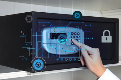 Image of Woman opening black steel safe with electronic lock, closeup