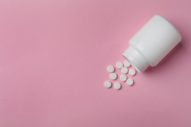 Photo of Bottle with pills on color background, flat lay. Space for text