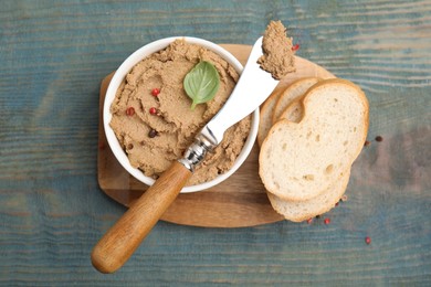 Photo of Delicious meat pate with spices, fresh bread and knife on blue wooden table, flat lay