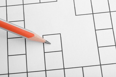 Pencil on blank crossword, top view. Space for text