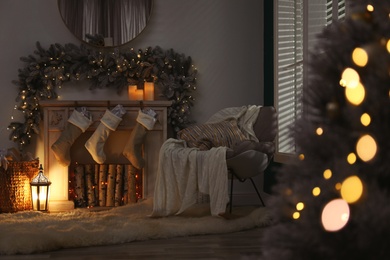 Photo of Fireplace with Christmas stockings in festive room interior