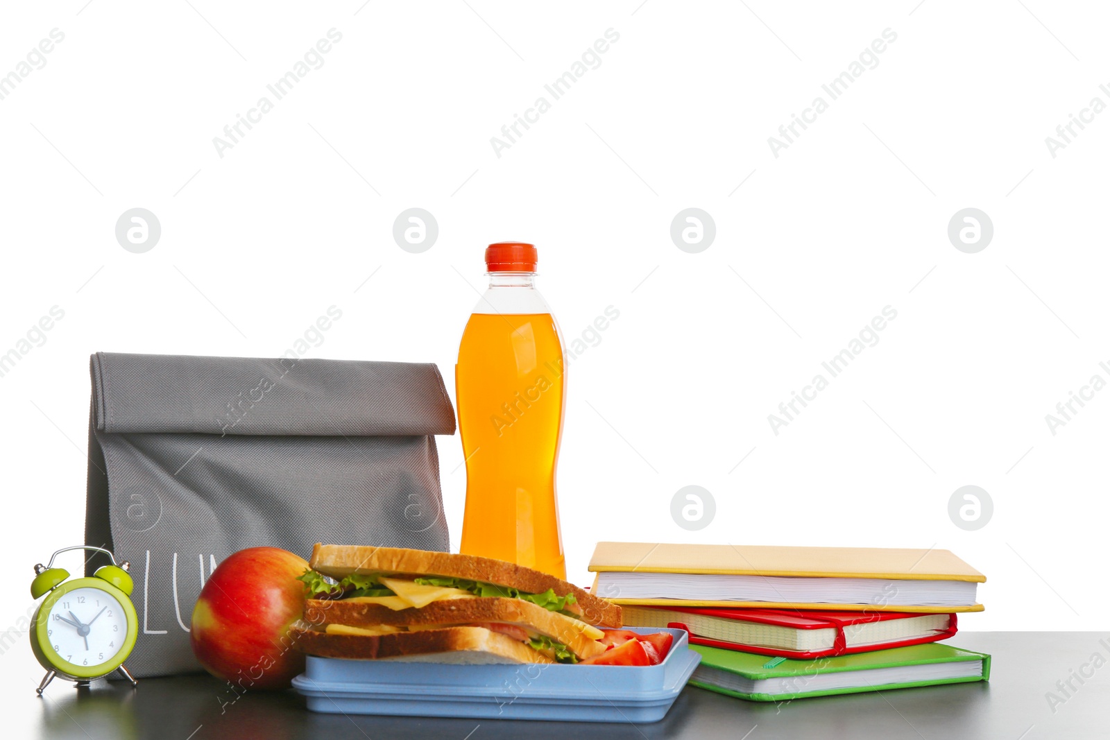 Photo of Lunch box with tasty sandwich, bottle of drink and stack of notebooks on table against white background