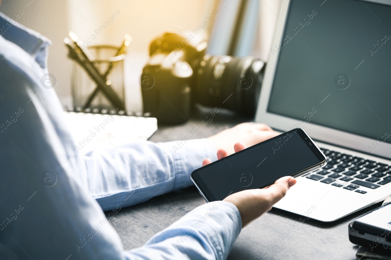 Image of Journalist with smartphone working at table in office, closeup