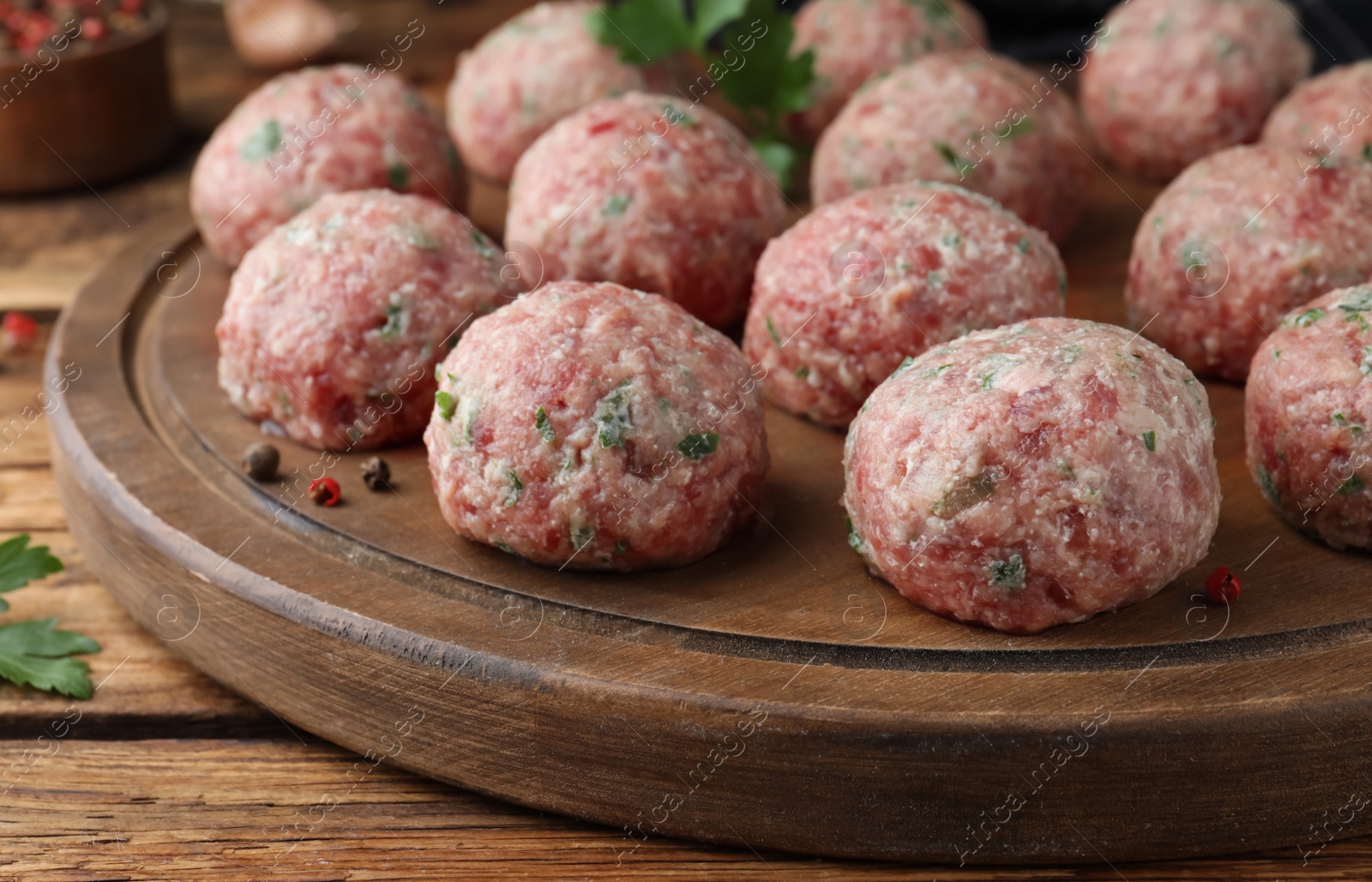 Photo of Many fresh raw meatballs on wooden table, closeup