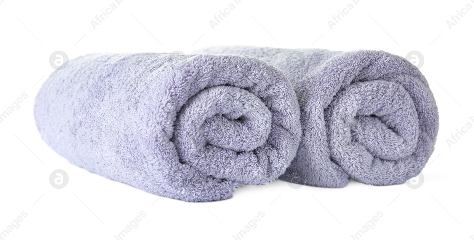 Photo of Rolled clean lilac towels on white background