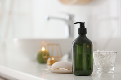 Photo of Green soap dispenser on white countertop in bathroom. Space for text