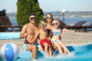 Happy family at poolside on sunny summer day