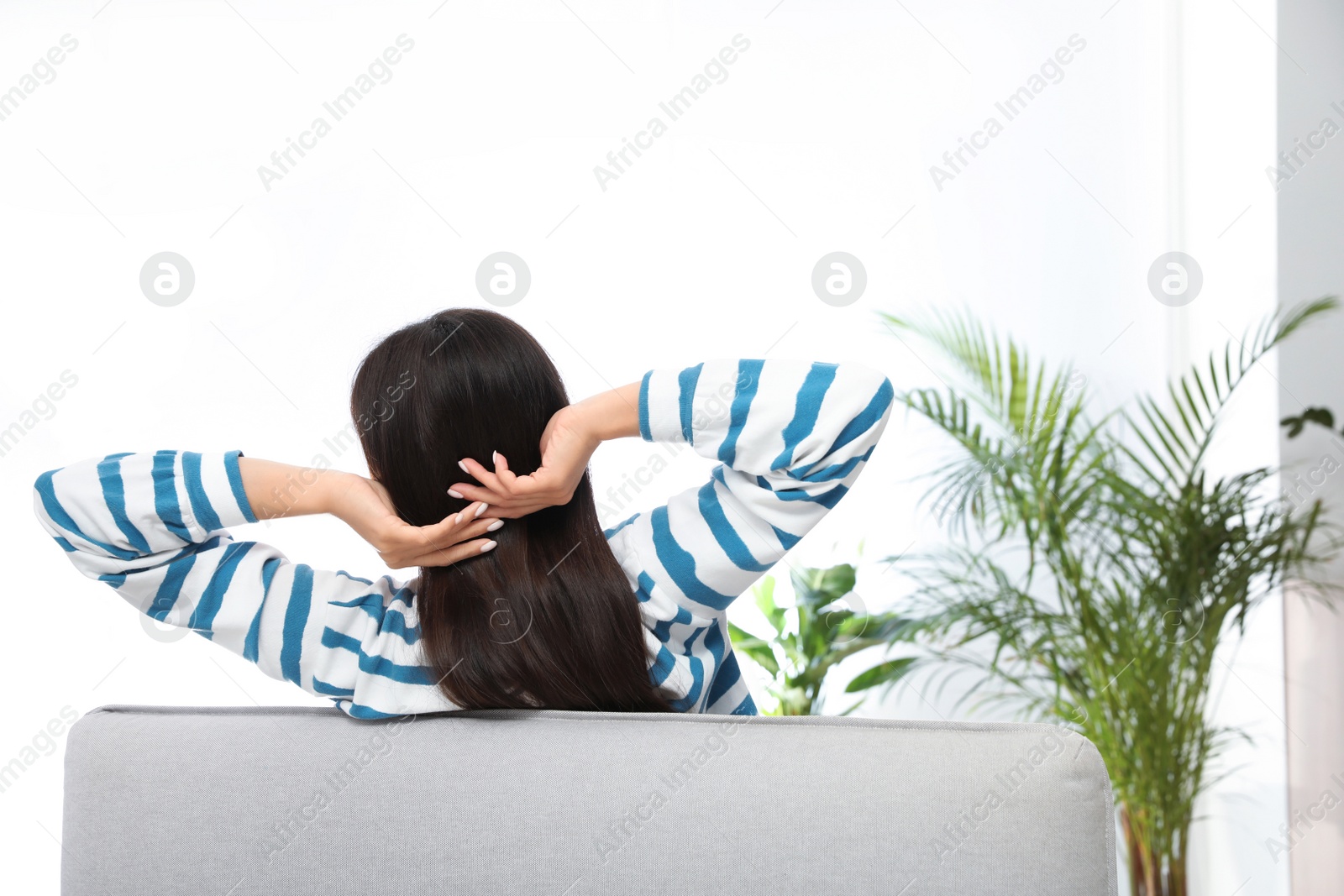 Photo of Young woman relaxing on couch at home