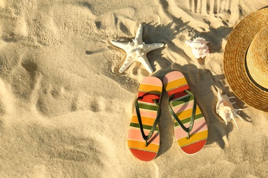 Flat lay composition with stylish beach accessories on sand. Space for text