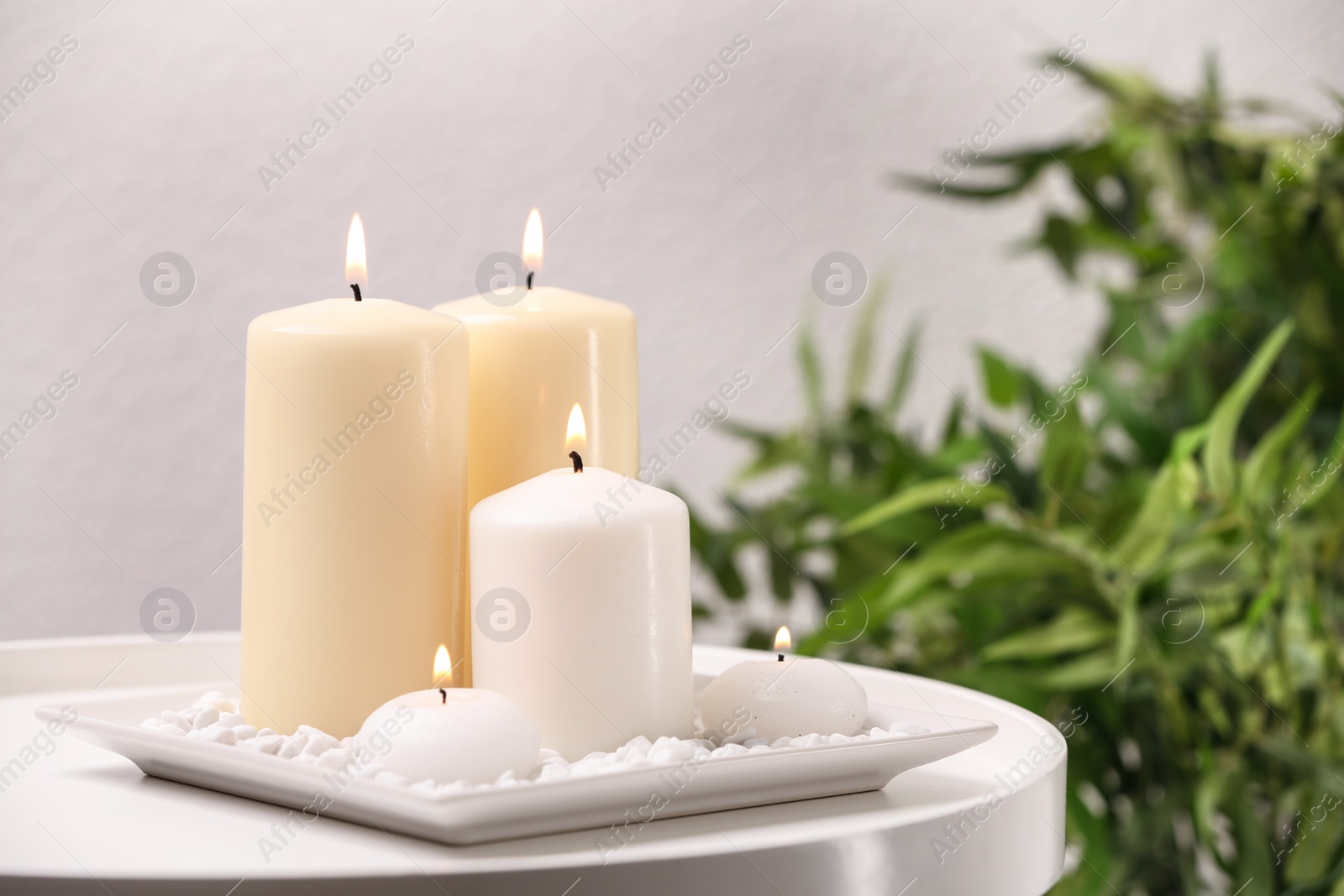 Photo of White plate with different candles on table. Space for text