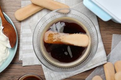 Photo of Flat lay composition with coffee and savoiardi biscuit cookies on wooden table. Making tiramisu cake