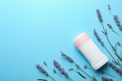 Photo of Female deodorant and lavender flowers on light blue background, flat lay. Space for text