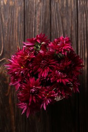 Photo of Beautiful pink chrysanthemum flowers on wooden table, top view
