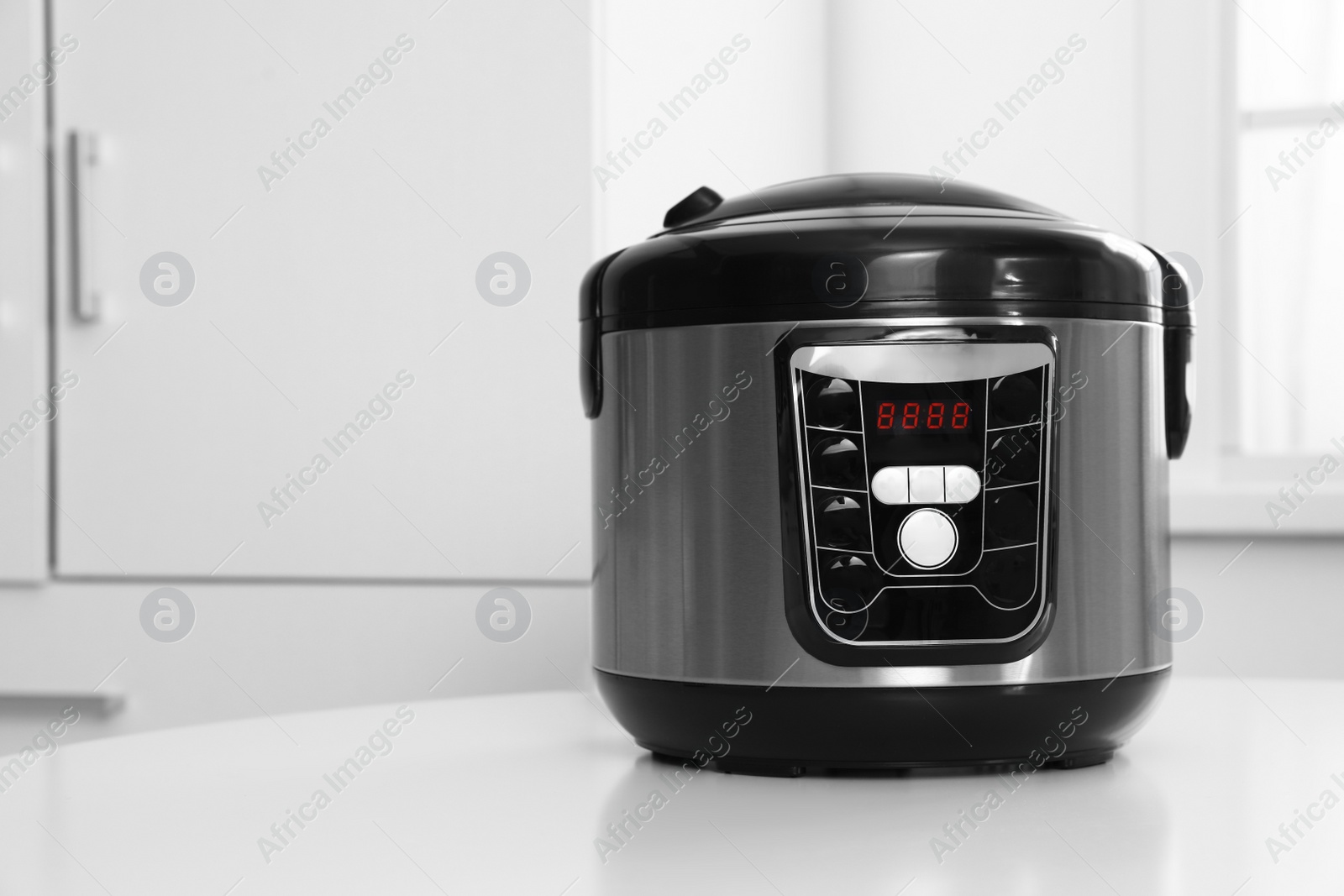 Photo of New modern multi cooker on table indoors. Space for text