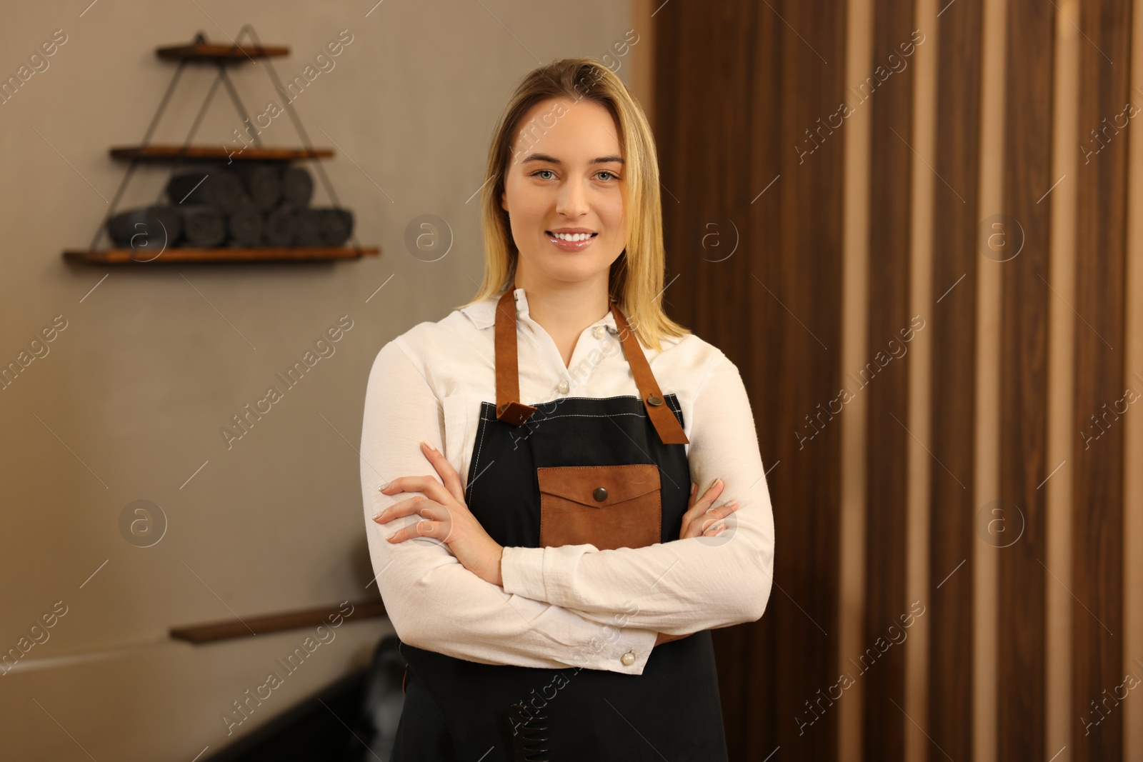 Photo of Portrait of professional hairdresser wearing apron in beauty salon