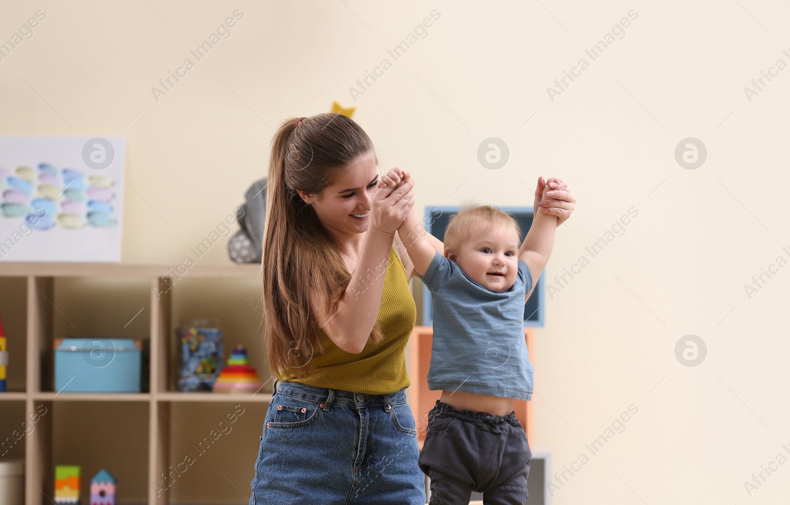 Photo of Teen nanny playing with cute little baby at home