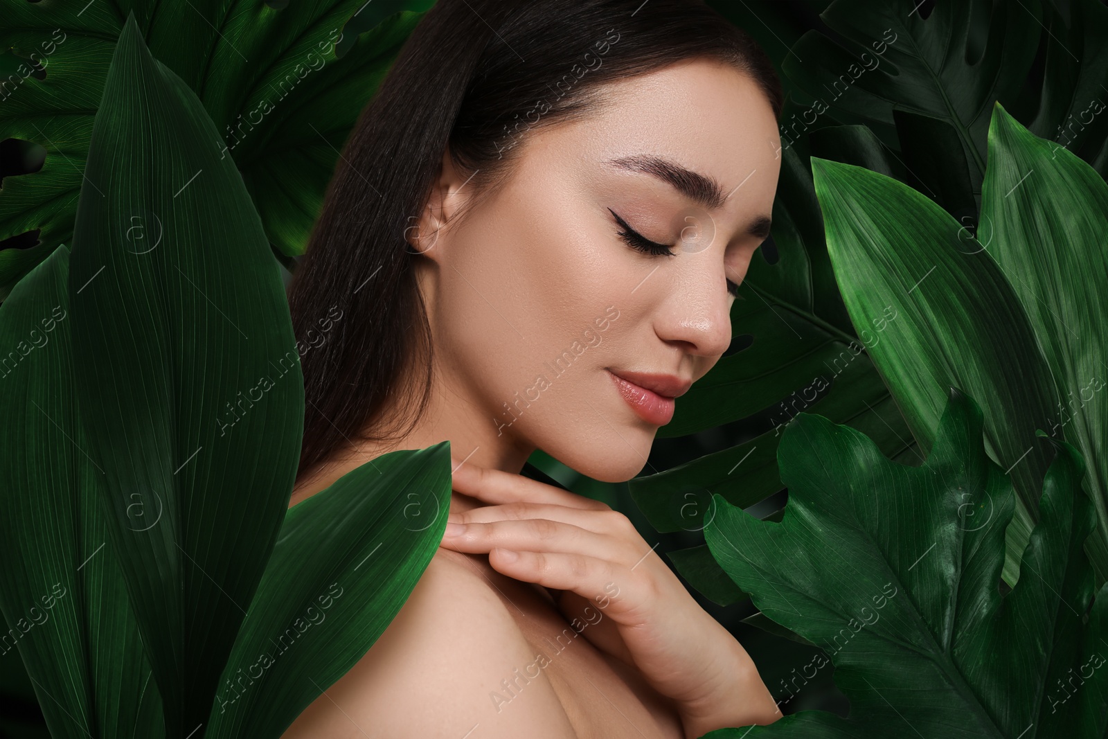 Image of Beautiful young woman feeling harmony while enjoying nature. Girl surrounded by green leaves