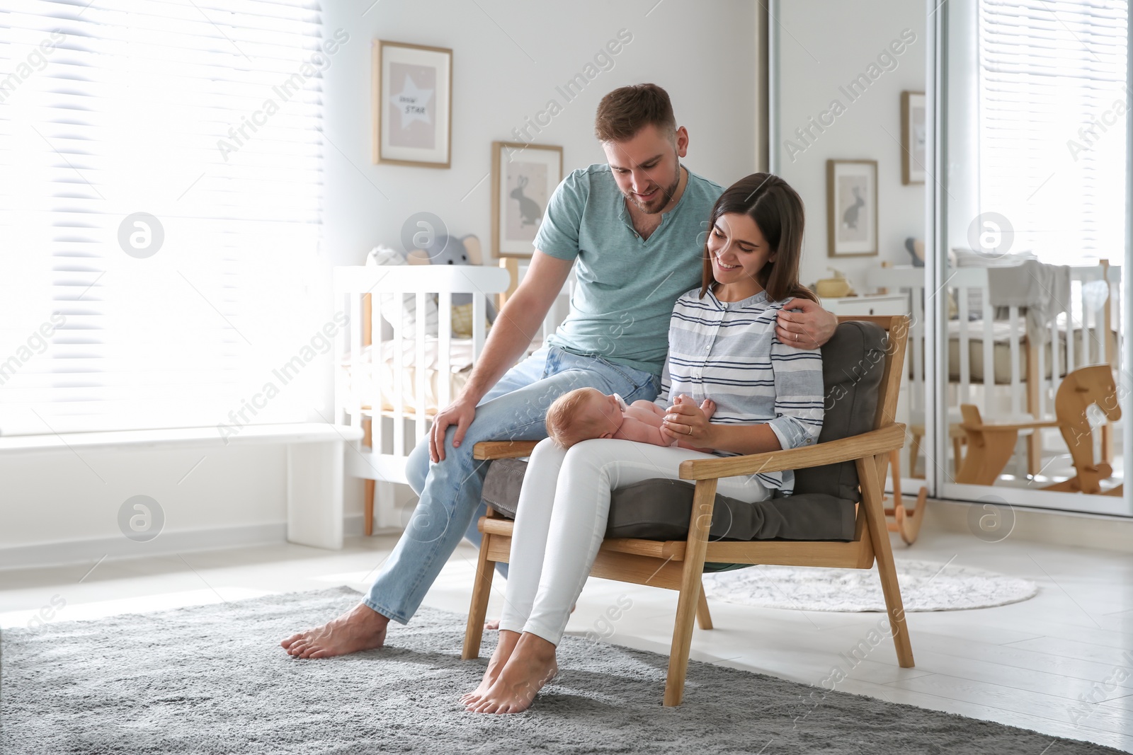 Photo of Happy couple with their newborn baby at home