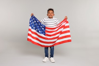 Photo of 4th of July - Independence Day of USA. Happy boy with American flag on light grey background