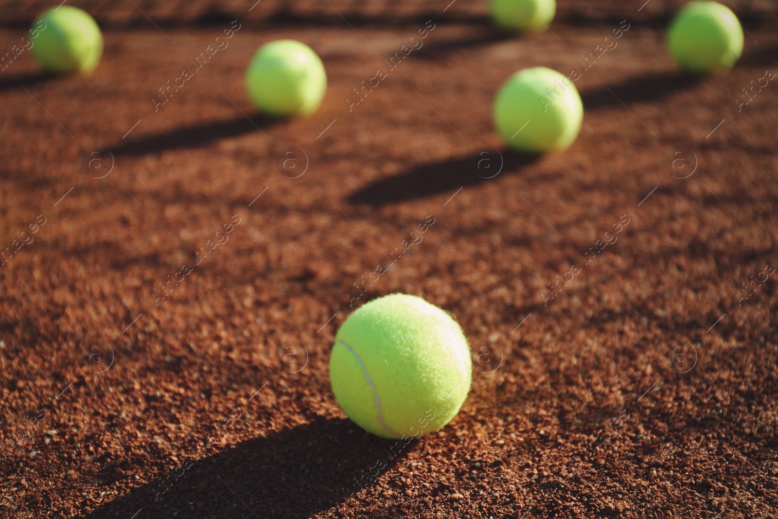 Photo of Bright yellow tennis ball on clay court