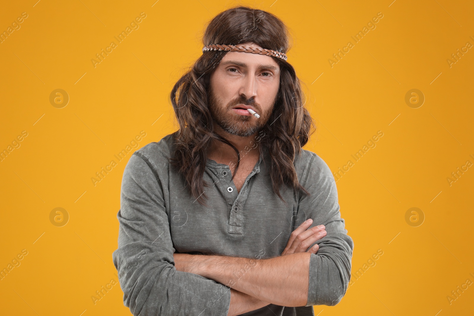 Photo of Hippie man smoking cigarette on orange background