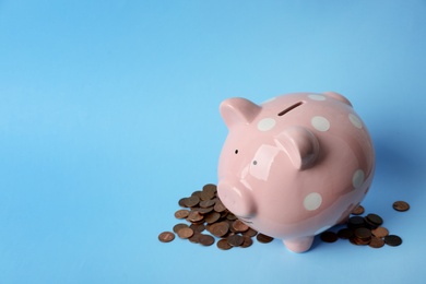 Photo of Cute piggy bank and coins on color background. Space for text