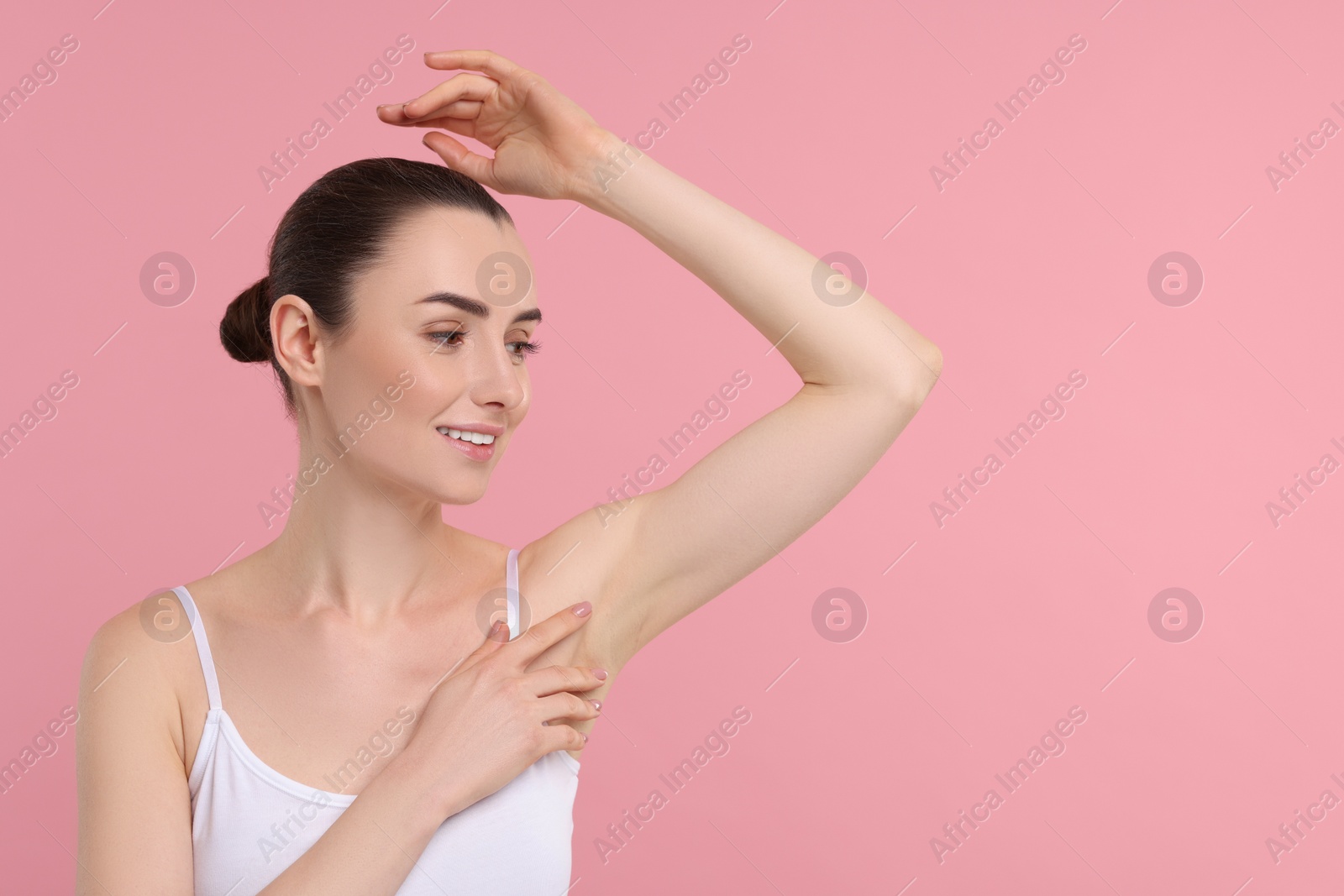 Photo of Beautiful woman showing armpit with smooth clean skin on pink background, space for text