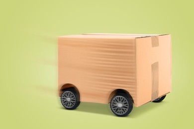 Image of Cardboard box on wheels against light yellowish green background. Order hurrying to client. Transportation and delivery service