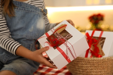 Photo of Little girl taking gift from Christmas advent calendar at home, closeup