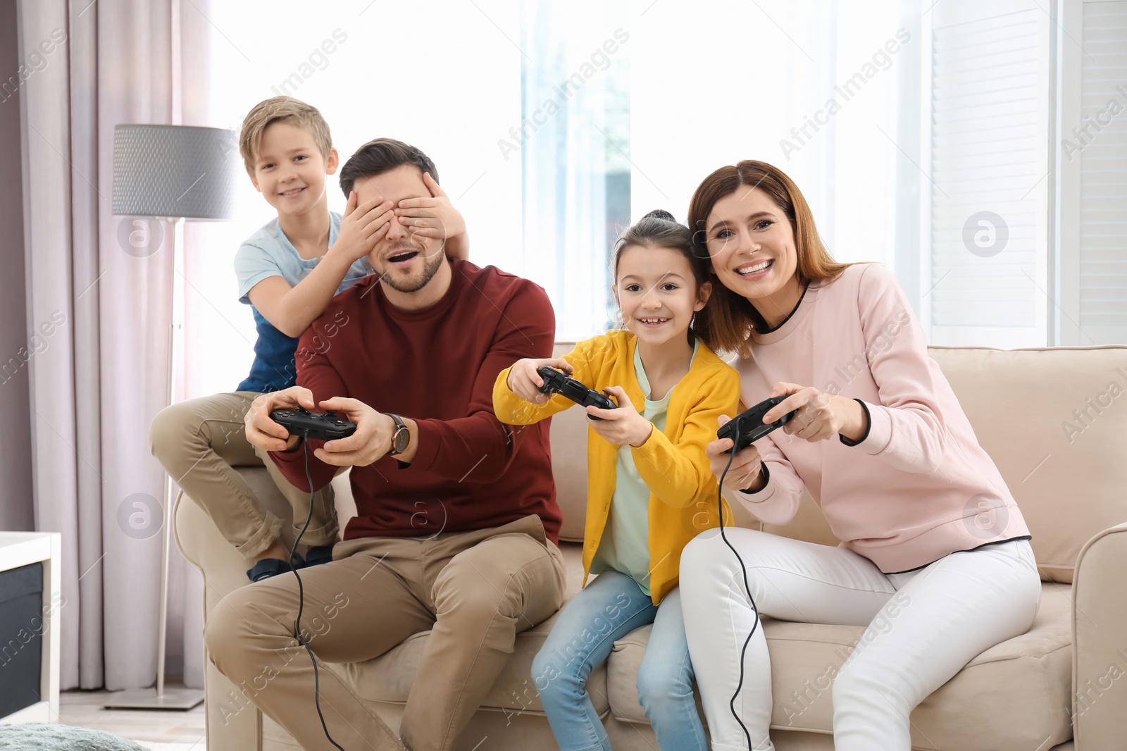 Photo of Happy family playing video games in living room