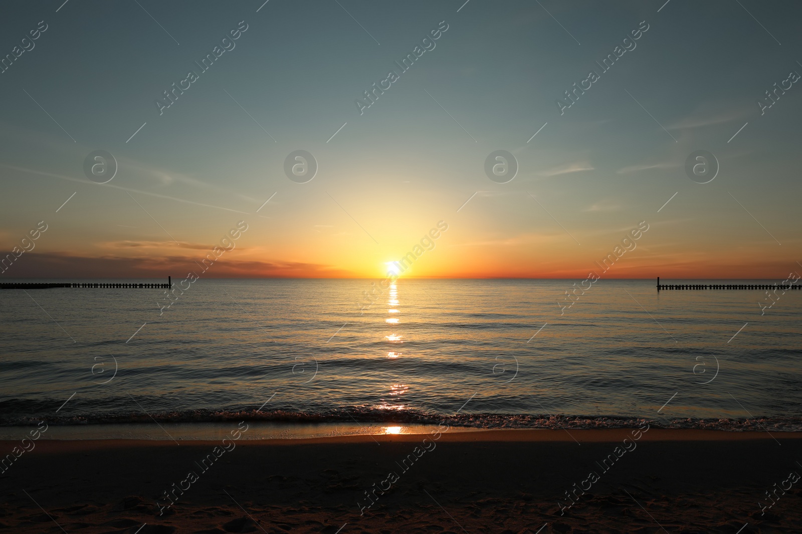 Picturesque view of sandy beach and sea at sunset Photo of Picturesque view of sandy beach and sea at sunset