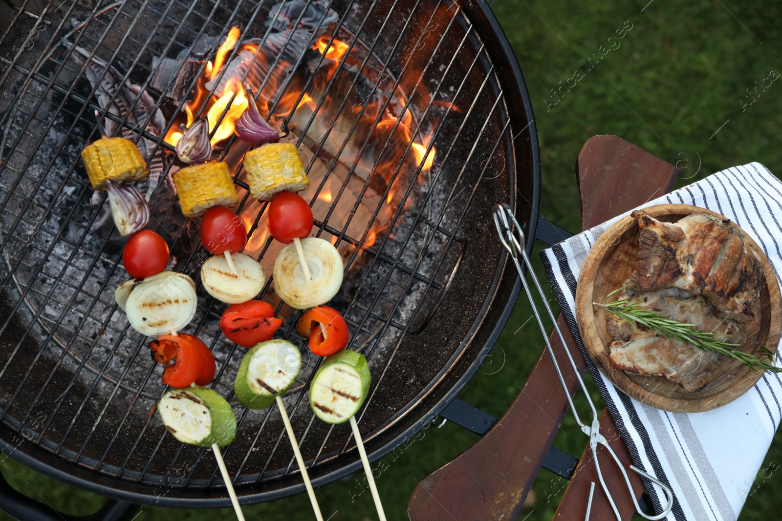 Photo of Cooked food products and grill barbecue outdoors, top view