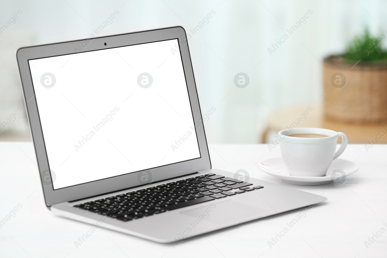 Photo of Laptop with blank screen on table indoors. Space for text