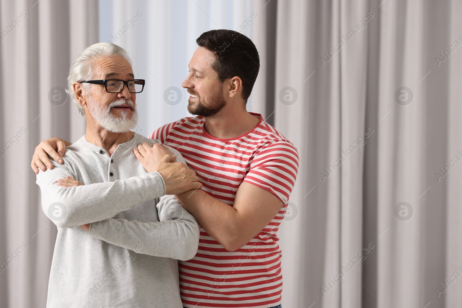 Photo of Happy son and his dad at home, space for text