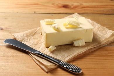 Tasty butter and knife on wooden table