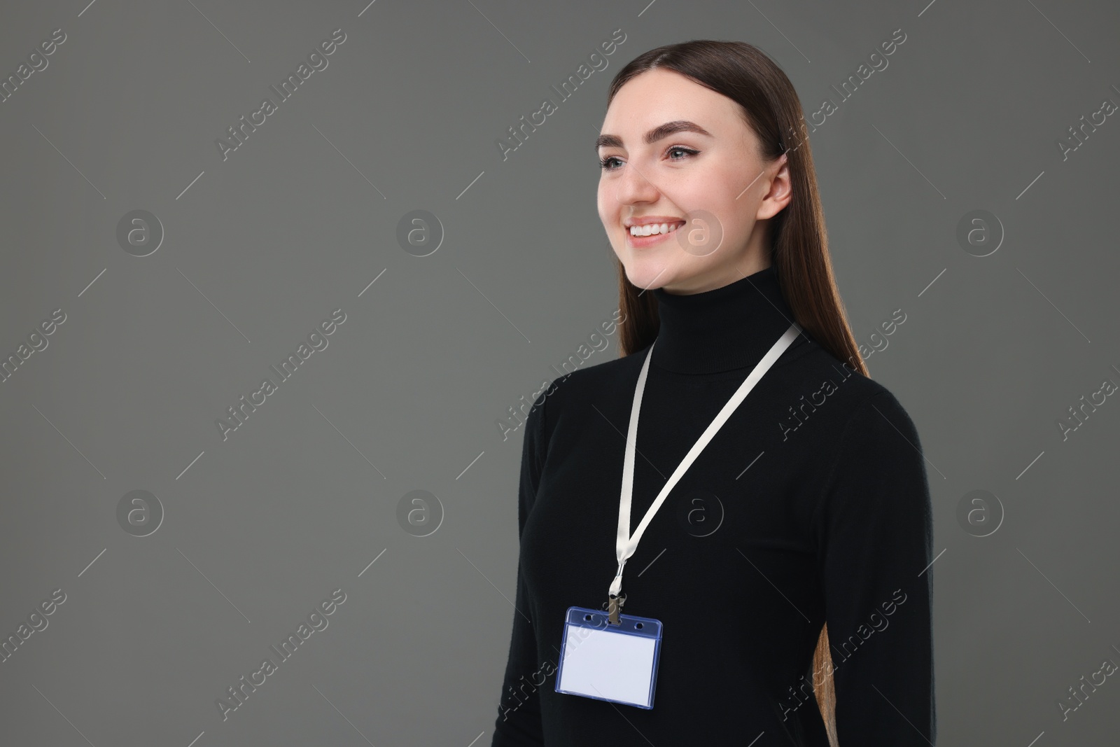 Photo of Happy woman with blank badge on grey background, space for text