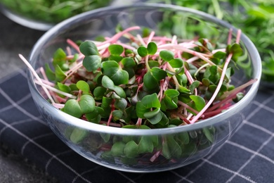 Glass bowl with fresh microgreen on table, closeup