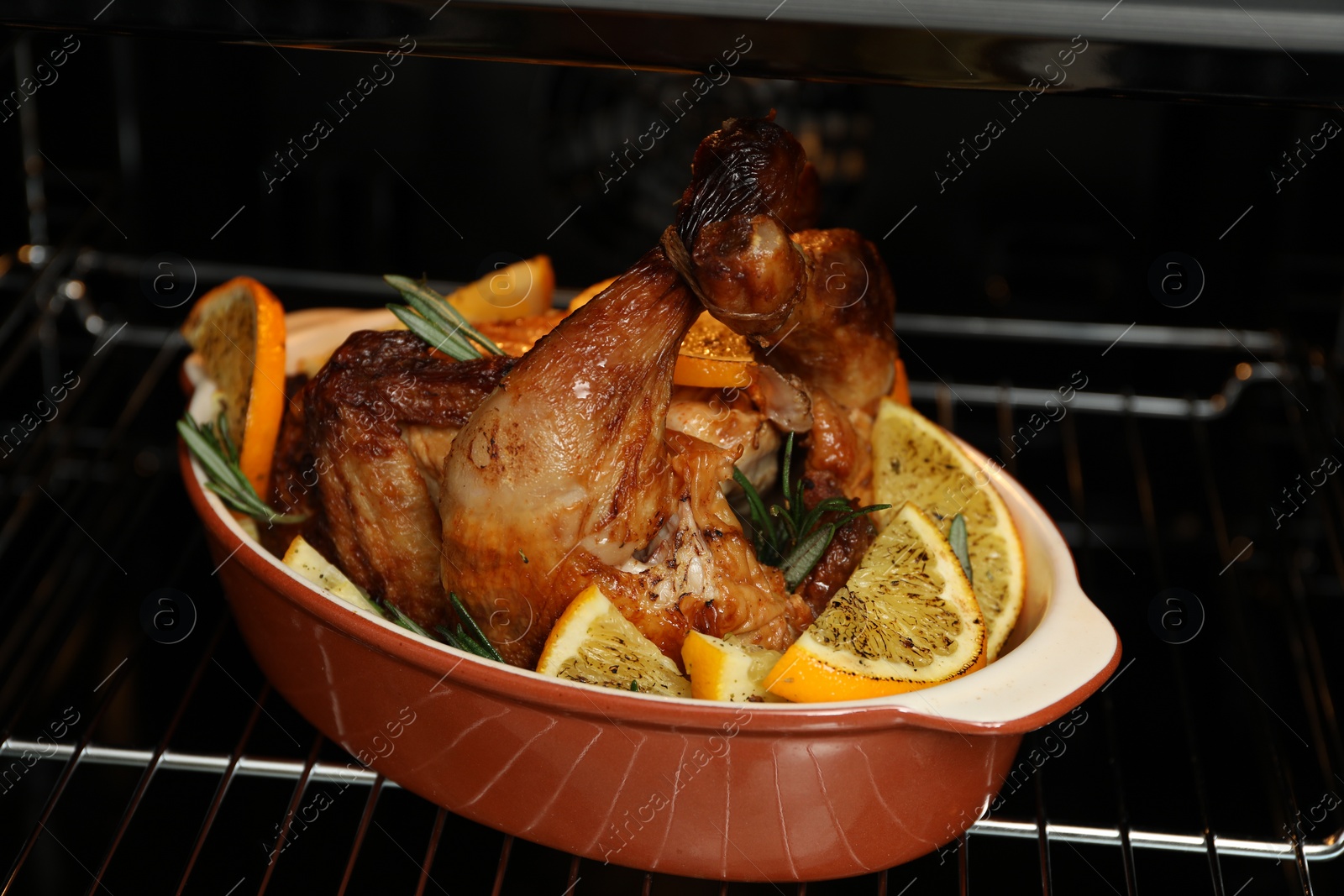 Photo of Chicken with orange slices baking in oven