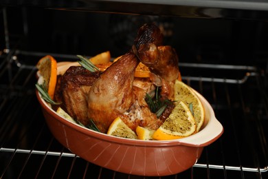 Chicken with orange slices baking in oven