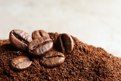 Coffee grounds and roasted beans on table, closeup