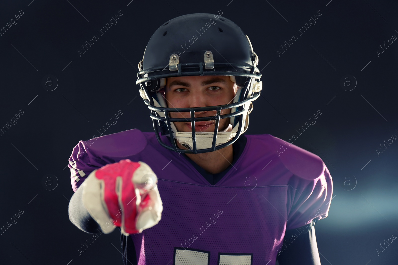 Photo of American football player in uniform on dark background