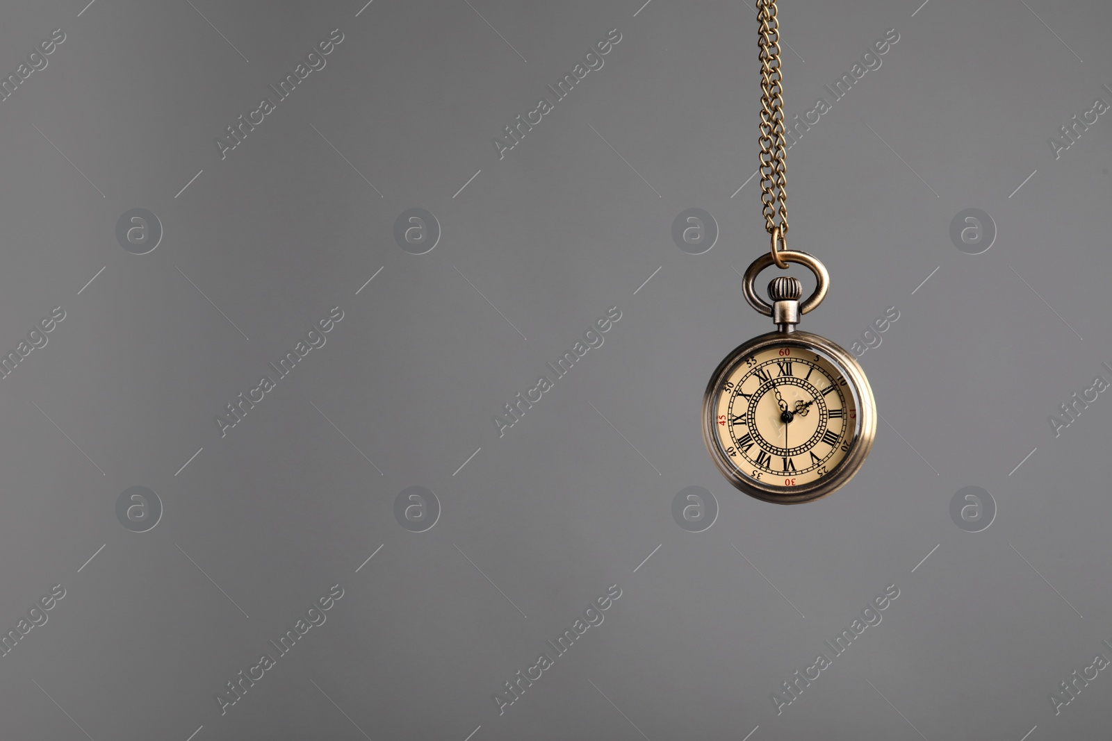 Photo of Stylish pendulum on grey background, space for text. Hypnotherapy session